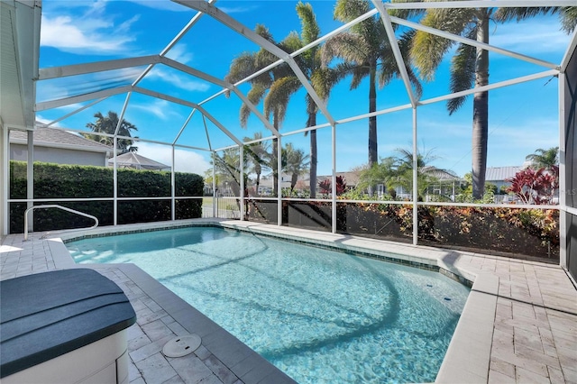 view of swimming pool featuring a patio and a lanai