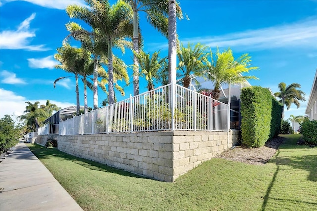 view of side of home with a lanai and a yard