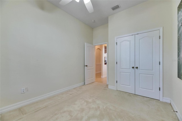 unfurnished bedroom featuring visible vents, a closet, carpet floors, baseboards, and ceiling fan