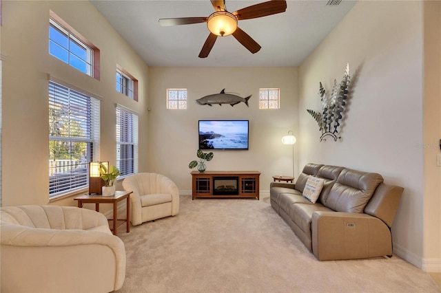 living room with visible vents, carpet floors, a high ceiling, baseboards, and ceiling fan