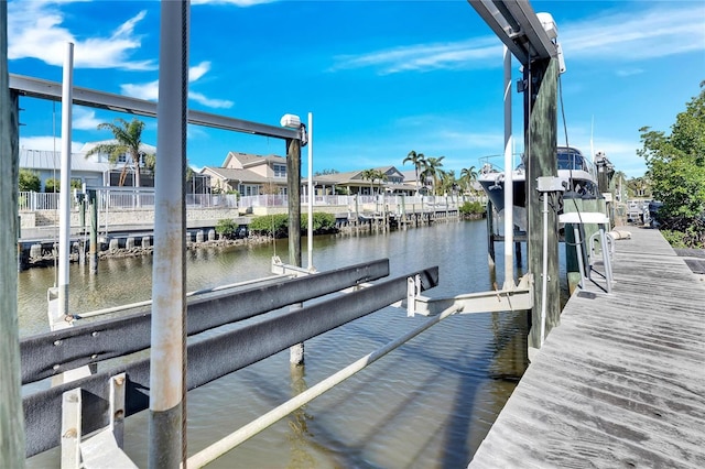 dock area featuring a water view, a residential view, and boat lift