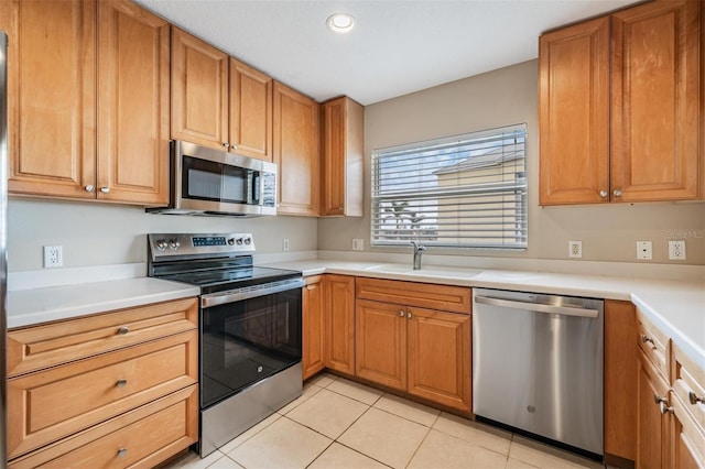 kitchen with sink, light tile patterned floors, and appliances with stainless steel finishes