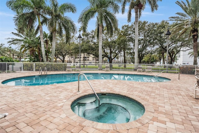 view of swimming pool featuring a patio area and an in ground hot tub