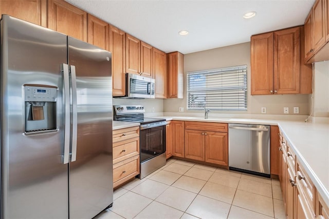 kitchen featuring appliances with stainless steel finishes, sink, and light tile patterned flooring