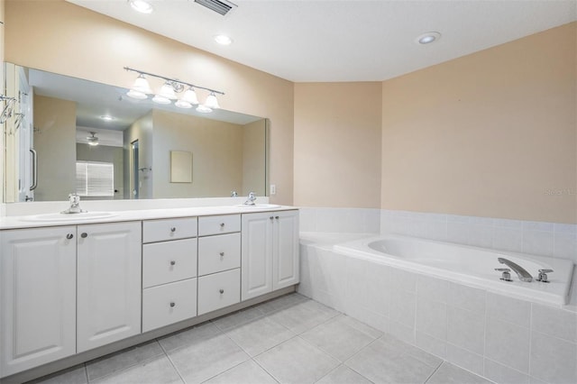 bathroom featuring tile patterned floors, vanity, and tiled tub