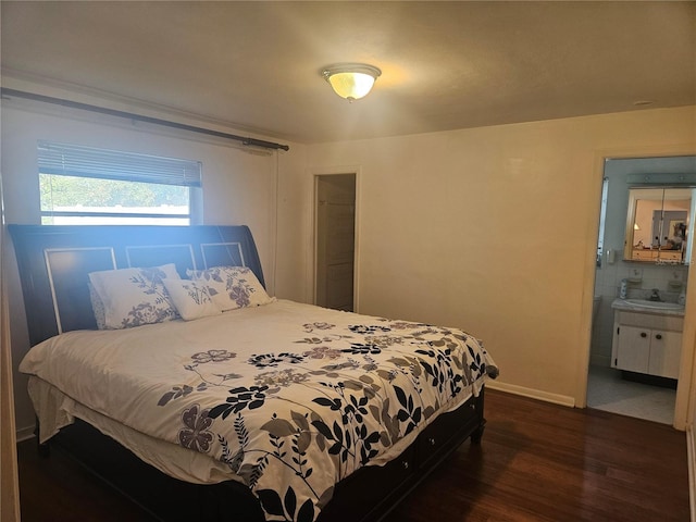 bedroom featuring dark hardwood / wood-style flooring, sink, and connected bathroom