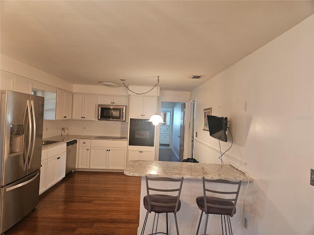 kitchen with black appliances, pendant lighting, white cabinets, and kitchen peninsula