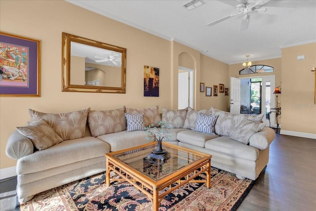 living room featuring a chandelier, crown molding, dark wood-type flooring, and a textured ceiling