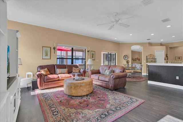 living room with dark hardwood / wood-style floors, ceiling fan, and ornamental molding