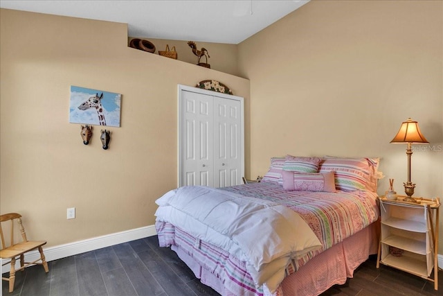 bedroom with lofted ceiling, a closet, and dark wood-type flooring