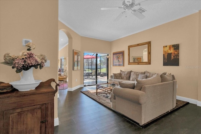 living room featuring a textured ceiling, ceiling fan, and dark wood-type flooring