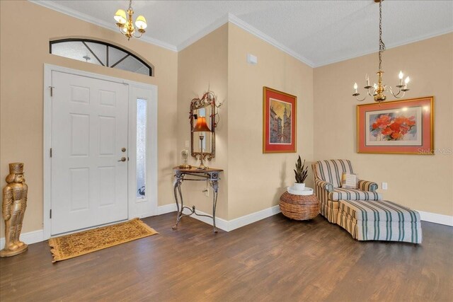 entrance foyer with a textured ceiling, dark wood-type flooring, crown molding, and an inviting chandelier