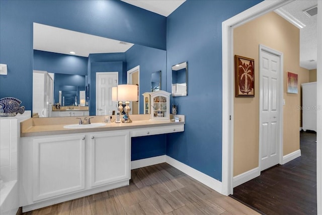 bathroom featuring vanity, wood-type flooring, and ornamental molding