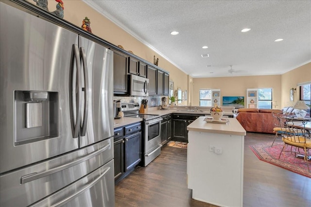 kitchen featuring sink, ceiling fan, a textured ceiling, appliances with stainless steel finishes, and tasteful backsplash