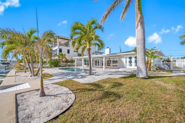 back of house featuring a patio area, a fenced in pool, and french doors