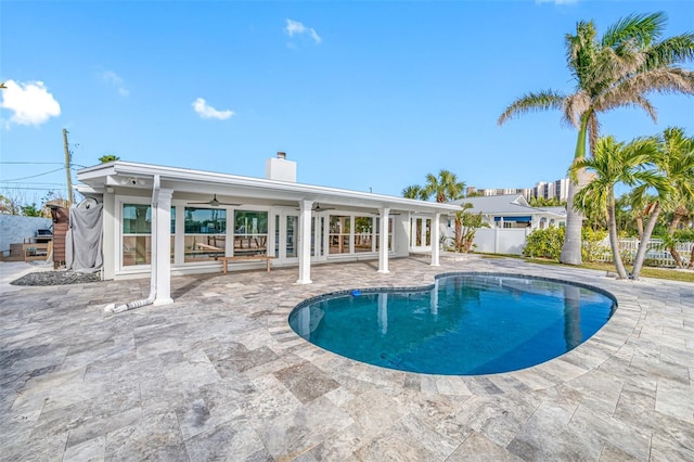 view of swimming pool with ceiling fan, a patio, and french doors