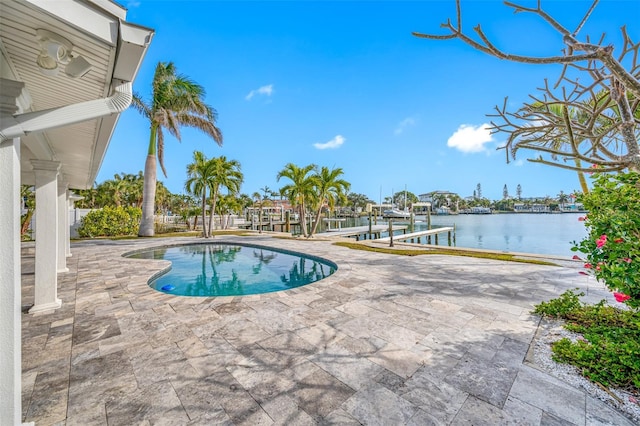 view of pool featuring a water view, a dock, and a patio area