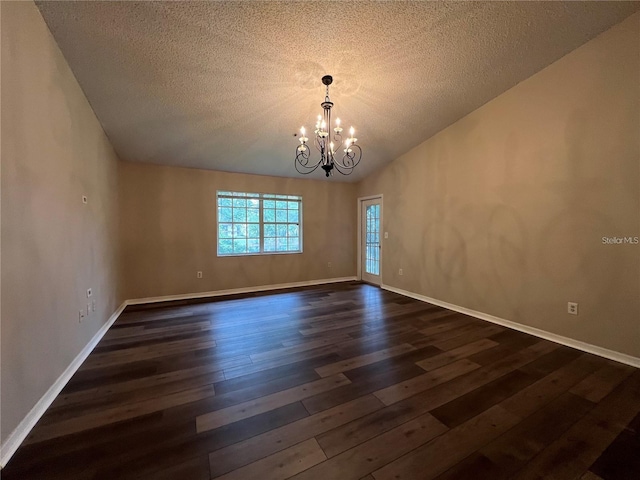 unfurnished room with vaulted ceiling, dark hardwood / wood-style flooring, a textured ceiling, and an inviting chandelier