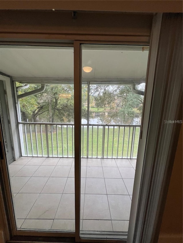 doorway featuring light tile patterned floors and a water view