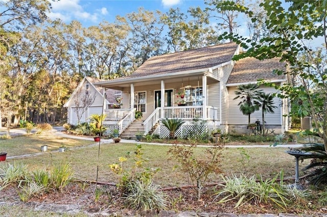 bungalow-style house featuring a porch, a garage, and an outbuilding