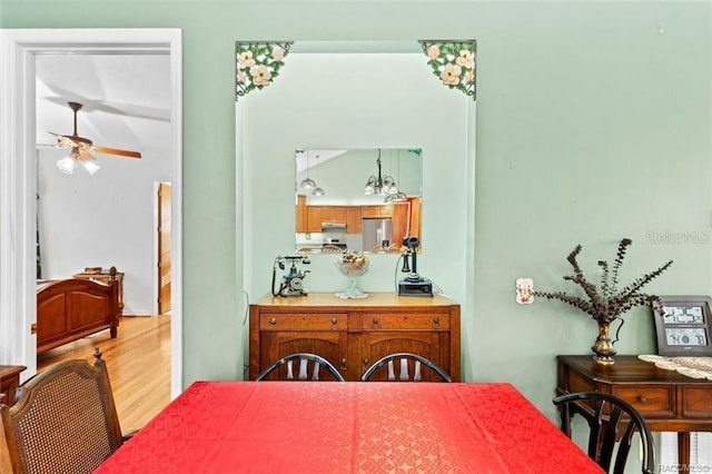 dining area with ceiling fan and wood-type flooring