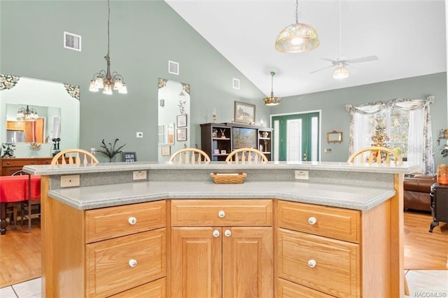 kitchen featuring ceiling fan with notable chandelier, light tile patterned floors, and high vaulted ceiling