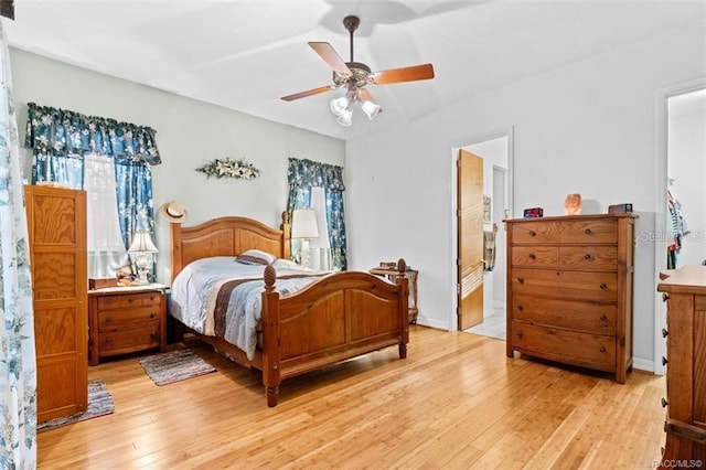 bedroom with ensuite bathroom, ceiling fan, and light wood-type flooring