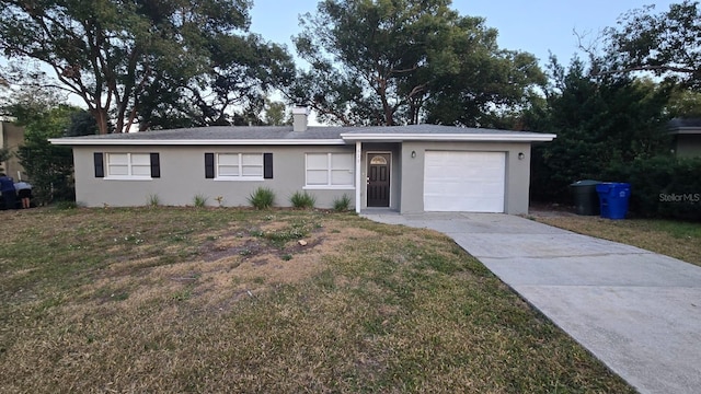 ranch-style home featuring a garage and a front lawn