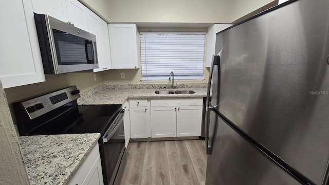 kitchen featuring sink, white cabinets, stainless steel appliances, and light hardwood / wood-style floors