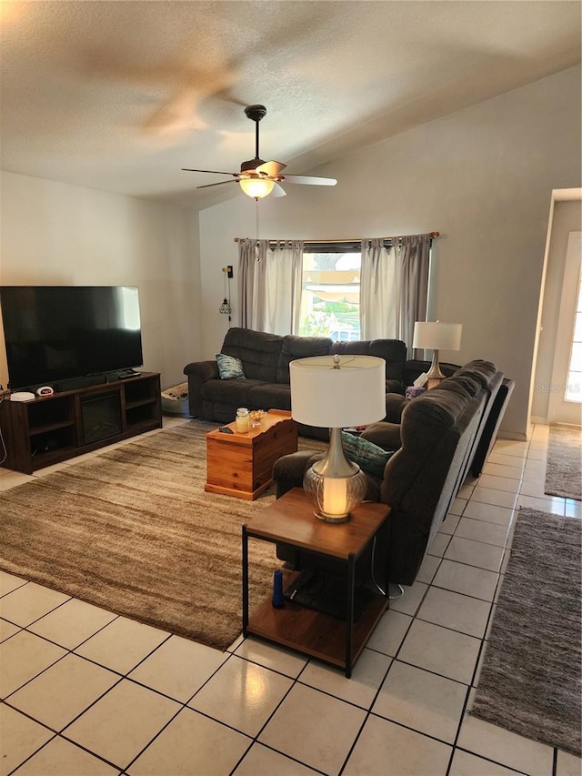 tiled living room featuring a textured ceiling, ceiling fan, and lofted ceiling