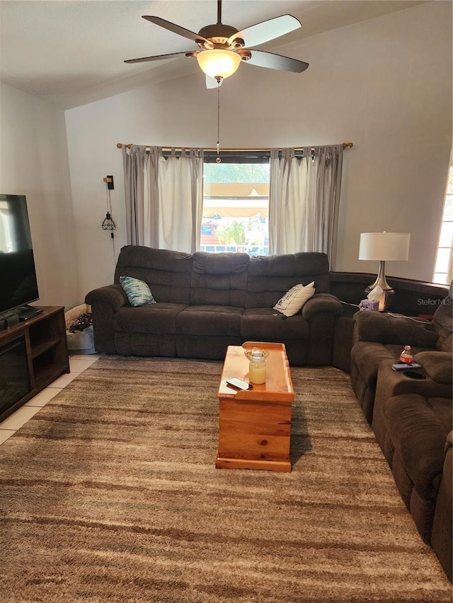 living room with tile patterned floors, ceiling fan, and vaulted ceiling