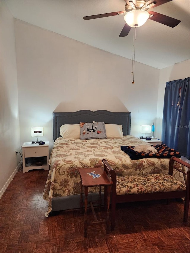 bedroom with dark parquet flooring, vaulted ceiling, and ceiling fan