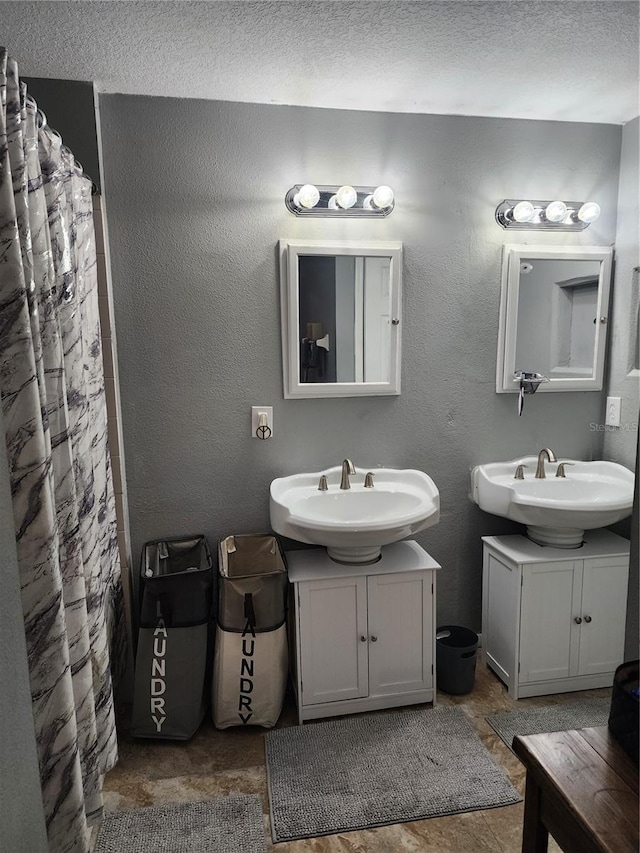 bathroom featuring curtained shower, vanity, and a textured ceiling