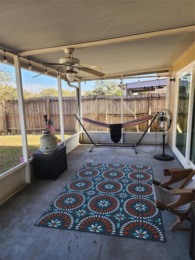 unfurnished sunroom featuring ceiling fan