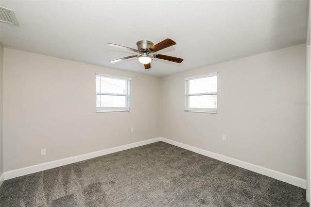 carpeted empty room with ceiling fan and a wealth of natural light