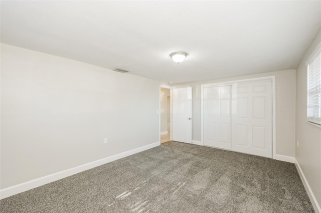 unfurnished bedroom featuring carpet and a closet