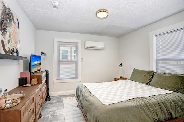 bedroom with a textured ceiling and a wall unit AC