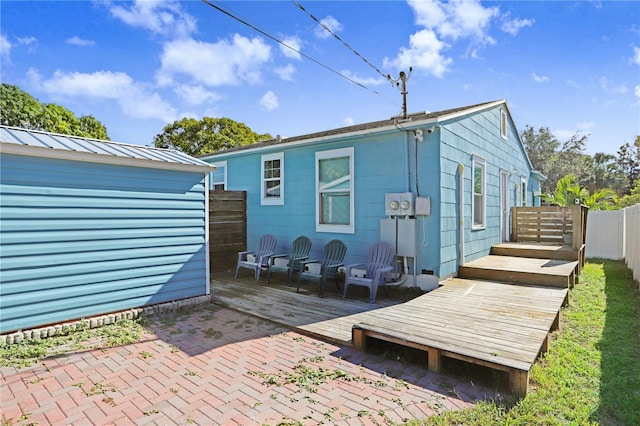 rear view of property featuring a patio area and a wooden deck