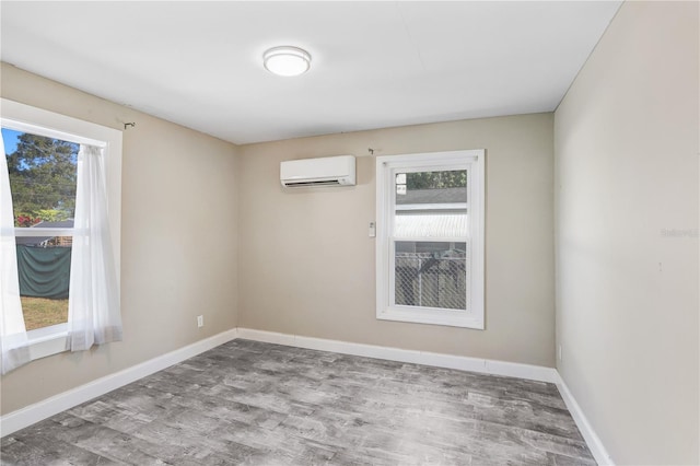 spare room featuring light hardwood / wood-style flooring and a wall mounted air conditioner