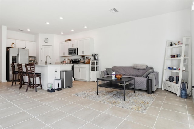 living room with light tile patterned floors, recessed lighting, and visible vents