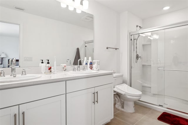 bathroom with tile patterned floors, vanity, a shower with shower door, and toilet