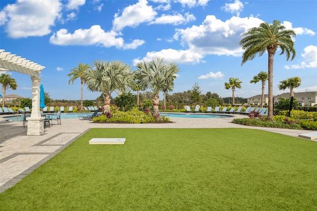 view of property's community featuring a patio area, a yard, and a pool