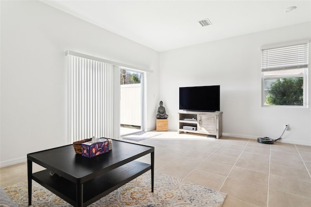 living room featuring light tile patterned flooring, visible vents, and baseboards