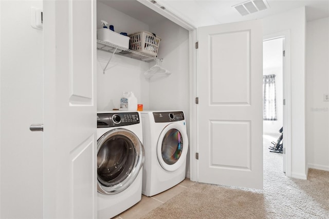 laundry room featuring visible vents, light carpet, washer and clothes dryer, light tile patterned floors, and laundry area