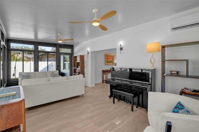 living room with ceiling fan, light hardwood / wood-style floors, and a wall mounted air conditioner