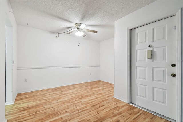 spare room with a textured ceiling, light hardwood / wood-style flooring, and ceiling fan