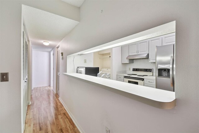 kitchen featuring stainless steel fridge, tasteful backsplash, independent washer and dryer, white cabinets, and white electric range