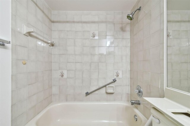 bathroom featuring vanity and tiled shower / bath