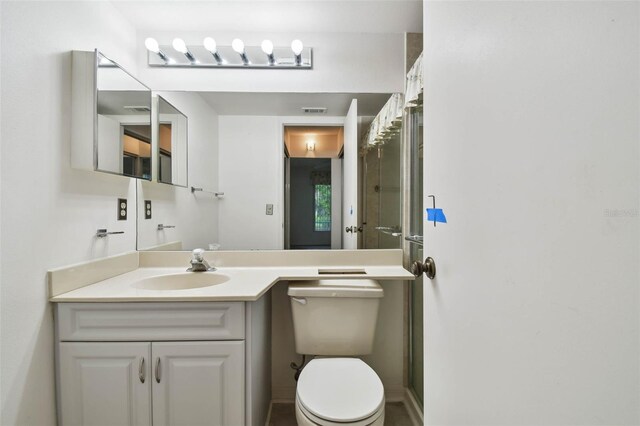 bathroom featuring vanity, toilet, and walk in shower