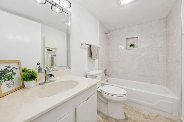 full bathroom with vanity, tiled shower / bath combo, and toilet